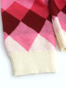 Women's V-neck knit sweater featuring red and pink argyle pattern with ribbed cuffs