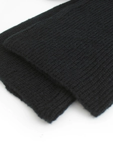 Macro shot of black ribbed knit texture on long sleeve sweater set and warm accessories