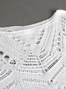 Λήψη macro λευκού διάτρητου πλεκτού υφάσματος με λεπτομερή ακτινωτά σχέδια βελονάκι