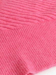 Close-up of rose pink v-neck sweater showing soft rib-knit texture and fabric detail