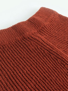 Macro detail of caramel knit fabric showing thick texture and ribbed edge craftsmanship