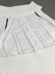 Detailed view of white cable knit texture and ribbed patterns on a slim fit halter top