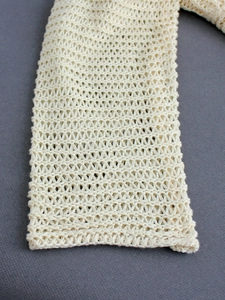 Chic cream knit V-neck cardigan featuring intricate openwork crochet texture for beachwear