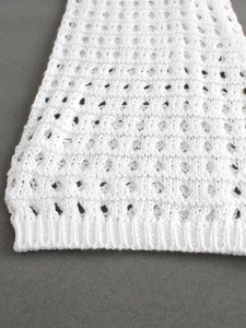 Pull blanc ajouré à manches longues pour femme en maille crochet sur fond gris foncé