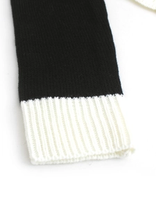 Gros plan sur un pull en maille noir et blanc avec détails de poignets côtelés