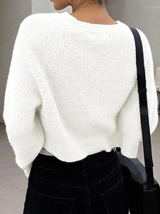Detailed back view of a white cropped knit sweater featuring a thick ribbed texture design