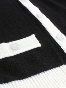 Gros plan d'un cardigan en tricot contrasté avec bordure blanche et boutons perles