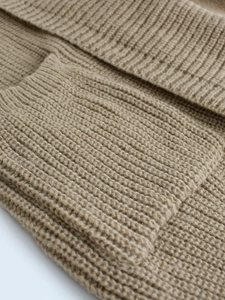 Macro shot of camel ribbed knit fabric detail showing soft texture and premium material