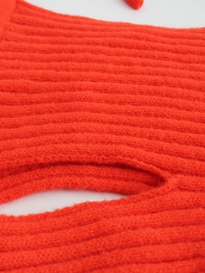 Detailed macro view of bright orange knit fabric with thick ribbed texture and soft yarn