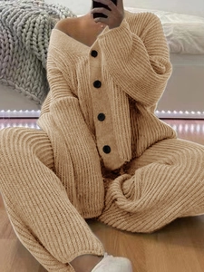Detail of warm beige knit cardigan set with vertical ribbed texture and large black buttons