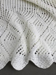 Haut de plage en crochet blanc avec des motifs géométriques ajourés et des bords ondulés