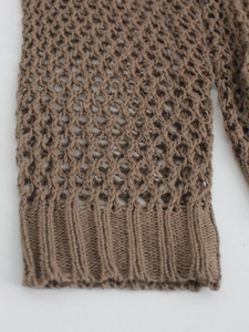 Close-up of brown open knit crochet texture and ribbed cuff on crewneck beach cover-up