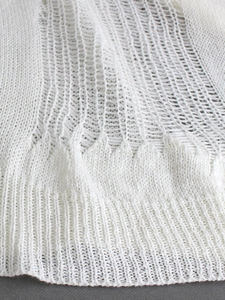Gros plan détaillé du tissu en maille crochetée blanche aux motifs texturés ondulés