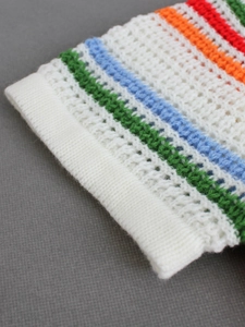 Detailed close-up of striped knit short sleeve cuff with colorful crochet hollow patterns