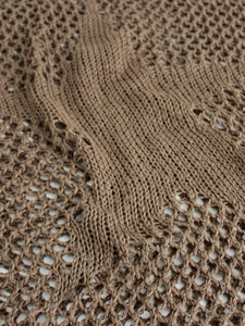 Close-up of brown hollow-out knit fabric with diamond mesh pattern and soft texture