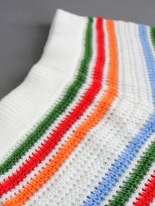 Close-up of ribbed knit texture with vibrant colorful horizontal stripes on white fabric