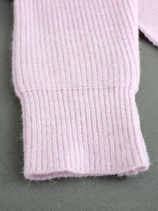 Close-up of pink knit sweater cuff featuring soft mohair texture and ribbed stitching