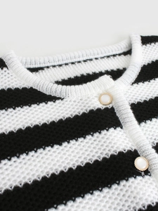 Close-up of black and white striped knit cardigan with pearl and gold rimmed buttons