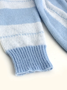 Close-up of light blue and white striped knit sweater sleeve with ribbed cuffs