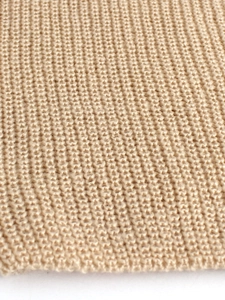 Close-up of beige chunky knit texture showing detailed weave on a sweater set