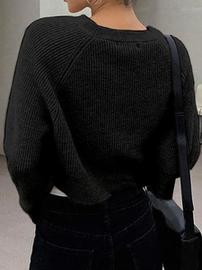 Back view of a black chunky knit sweater with ribbed texture and loose fit design