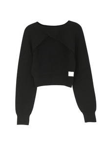 Detailed close-up of the black knit sweater featuring a unique overlapping cross-cut design