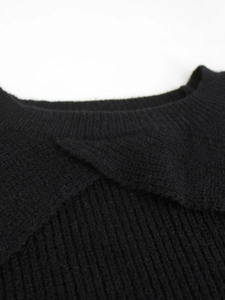 Close-up of a black knit sweater featuring a unique overlapping crew neckline and ribbed texture