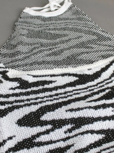 Knitted halter neck sundress featuring black and white patterned stitching and lace-up detail