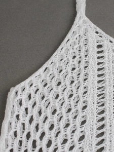 Detailed macro view of white crochet knit tank top showing intricate openwork patterns