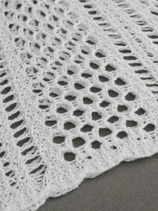 White hollow knit sweater vest with geometric crochet pattern for beach style
