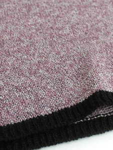 Detail der rosa-weiß melierten Strickware mit schwarzem Rippstrick-Abschluss