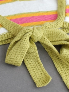 Detailed close-up of knitted fabric texture with colorful stripes and green tie knot