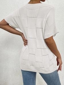 Detail shot of white knit top featuring textured checkerboard hollow patterns and relaxed fit