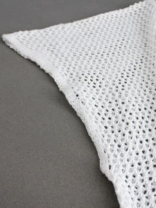 Vue macro d'un tissu en maille blanche montrant les détails et la texture du crochet
