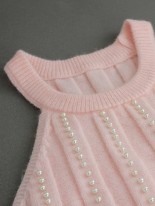 Pink sleeveless knit top featuring vertical ribbing and delicate white pearl embellishments