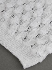 White sleeveless hollowed knit sweater vest with wavy texture and ribbed edge trim