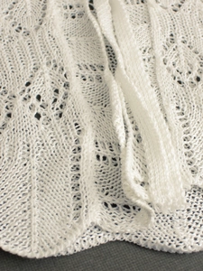 Détail du motif ajouré au crochet blanc et de la bordure festonnée délicate