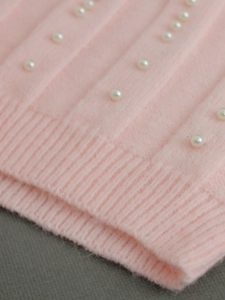Pink sleeveless knit vest with pearl embellishments and ribbed hem for women