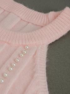 Pale pink sleeveless knit sweater with crew neck and diagonal faux pearl embellishments