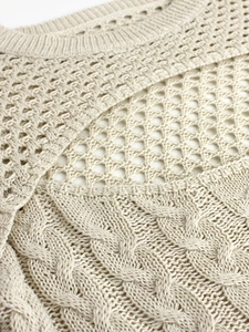 Maglione in maglia beige con collo a coste, motivi a rete e classiche trecce decorative
