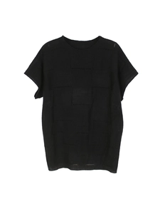 Detail shot of black knitted top featuring a grid hollow-out pattern and round neck