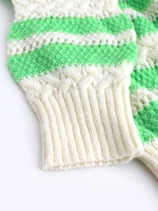 Women's green and white striped knit sweater with detailed cable knit pattern sleeves