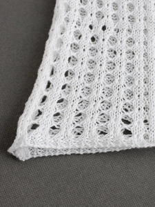 Vue macro détaillée de la maille tricotée blanche d'une robe d'été sans manches décontractée