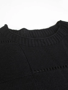 Close-up of crew neck detailing and ribbed knit texture on a black short sleeve top
