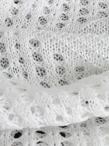 Gros plan détaillé sur un tissu en maille blanche avec des motifs ajourés