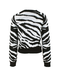 Back view of women's long sleeve crewneck knit sweater with black and white zebra pattern