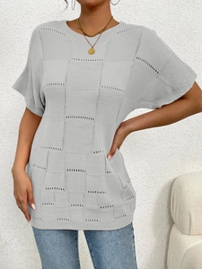 Detail view of grey short-sleeved knit top with checkered texture and hollow pattern