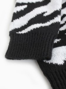 Detailed view of women's zebra print sweater cuff featuring ribbed knit texture and soft fabric