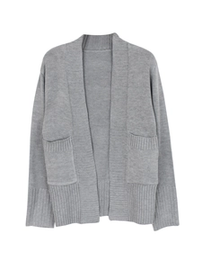 Detail of grey knit cardigan featuring large side pockets and ribbed texture cuffs