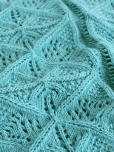 Macro detail of mint green diamond crochet knit sweater with soft mohair texture